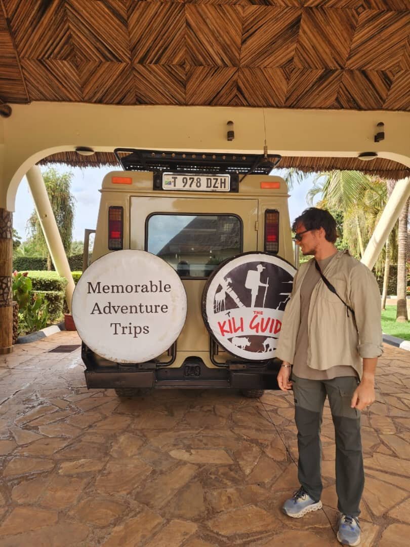 A traveller beside The Kili Guides safari vehicle